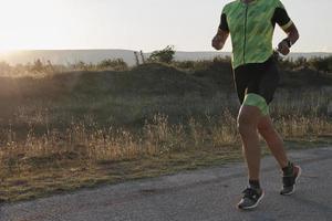 atleta de triatlón corriendo en el entrenamiento matutino foto