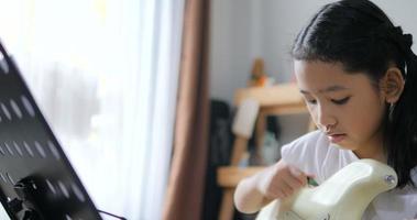 petite fille asiatique apprenant à jouer de la guitare de base en utilisant une guitare électrique pour la musique instrumentale débutant auto-apprenant à la maison video