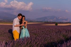 couple in lavender field using smartphone photo