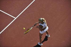 mujer joven jugar al tenis al aire libre foto