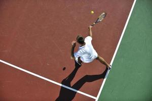 joven jugar al tenis al aire libre foto