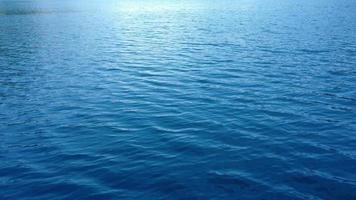 een prachtige hoge hoek van het brede meer met helderblauw water dat zachte golven maakt tijdens de zonnige dag video