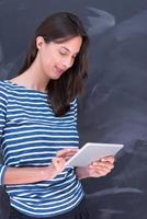 woman using tablet  in front of chalk drawing board photo
