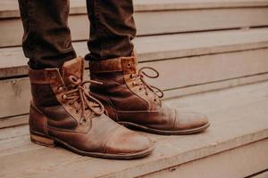 Image of mans brown footwear standing on wooden steps. Male in trousers and shaggy shoes on threshold. Horizontal view photo