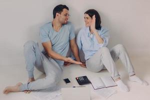 People and agreement concept. Satisfied happy woman and man clap their hands, look happily at each other, being successful team of workers, analyze documentation, calculate finances, isolated on white photo