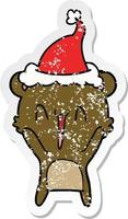 happy bear distressed sticker cartoon of a wearing santa hat vector