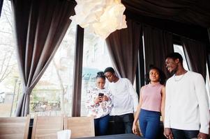 Happy african friends chatting in cafe. Group of black peoples meeting in restaurant. photo