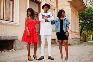 grupo de tres elegantes amigos de moda afro francia posaron en el día de otoño. modelo de hombre africano negro con dos mujeres de piel oscura. foto