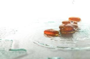 isolated wet zen stones with splashing  water drops photo