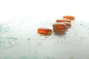 piedras zen húmedas aisladas con gotas de agua salpicadas foto