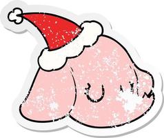 distressed sticker cartoon of a elephant face wearing santa hat vector