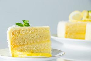 Lemon cake with coconut flakes. Piece of delicate vanilla dessert with cream. photo