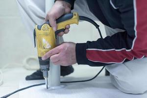 repairman working with drilling machine photo