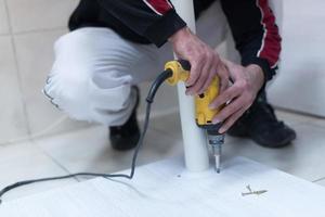 repairman working with drilling machine photo