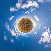 Little planet transformation of spherical panorama 360 degrees. Spherical abstract aerial view in field with awesome beautiful clouds. Curvature of space. photo