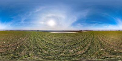 vista de ángulo de 360 grados de panorama hdri esférico completo sin costuras entre campos a principios del día de primavera con sol en cielo despejado con halo en proyección equirectangular, listo para contenido vr ar foto