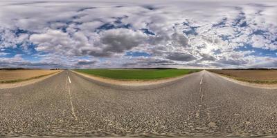 vista de ángulo de 360 grados de panorama hdri esférico completo sin tráfico en carretera asfaltada entre campos por la noche con cielo nublado. Panorama 360 en proyección equirectangular, contenido vr ar foto