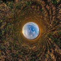 Inversion of little planet transformation of spherical panorama 360 degrees. Spherical abstract aerial view in field with awesome beautiful clouds. Curvature of space. photo
