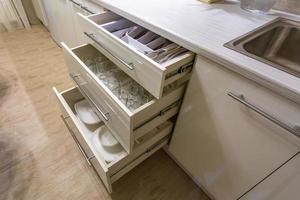 cutlery spoons forks knives and tea spoon on the shelf in the kitchen cupboard photo