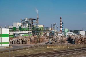 pipes of woodworking enterprise plant sawmill near river. Air pollution concept. Industrial landscape environmental pollution waste of thermal power plant photo