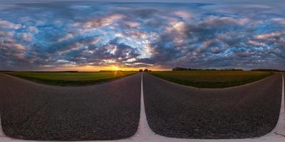 Full spherical seamless panorama 360 degrees angle view on no traffic asphalt road among fields in evening  before sunset with cloudy sky. 360 panorama in equirectangular projection, VR AR content photo