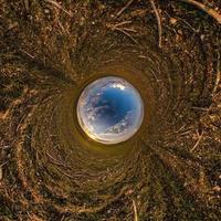 Inversion of little planet transformation of spherical panorama 360 degrees. Spherical abstract aerial view in field with awesome beautiful clouds. Curvature of space. photo