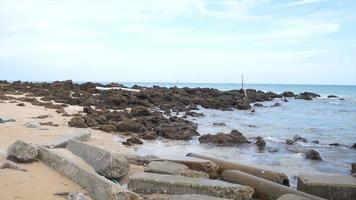 Cámara lenta mar ola costa a playa con piedra y roca video