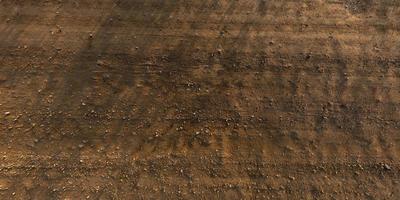 view from above on texture of gravel road with car tire tracks photo