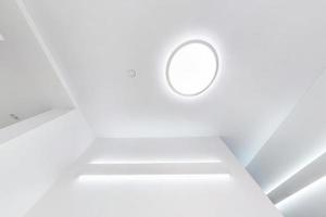 suspended ceiling with halogen spots lamps and drywall construction in empty room in apartment or house. Stretch ceiling white and complex shape. photo