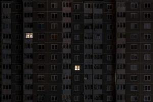 panorama nocturno plano de luz en ventanas de edificios de varios pisos. la vida en la gran ciudad. concepto para una pareja enamorada en aislamiento foto