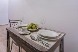 mesa de invitados en el interior de la moderna cocina de lujo en apartamentos tipo estudio de estilo minimalista con color verde foto