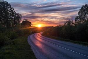 landscape of road with blue red pink evening sky with beautiful clouds before sunset photo