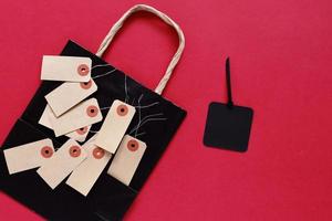 Mock up pf blank sale tag with shopping bag on red background, copy space,  shopping concept photo