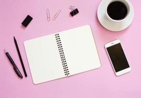 Creative flat lay mockup design of workspace desk with blank notebook, smartphone, coffee, stationery with copy space background photo