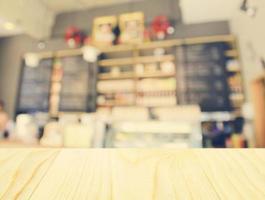 Empty wooden table and blurred cafe background photo