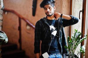 Beard asian man in casual wear stand inside house on stairs against window. photo