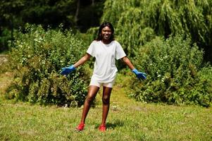 mujer voluntaria africana en el parque. Concepto de voluntariado, caridad, personas y ecología de África. foto
