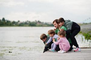 Father love. Dad with four kids outdoor on the pier. Sports large family spend free time outdoors. photo