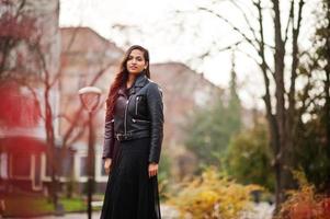 Pretty indian girl in black saree dress and leather jacket posed outdoor at autumn street. photo