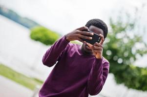 hombre afroamericano haciendo fotos en su teléfono móvil.