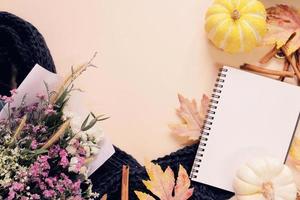 Flat lay style of autumn and thanksgiving with pumpkin, notebook, scarf, bouquet of flower and maple leaf, copy space photo