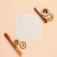 Flat lay of blank paper with cinnamon sticks and herb on yellow background, autumn and thanksgiving concept, minimal style photo