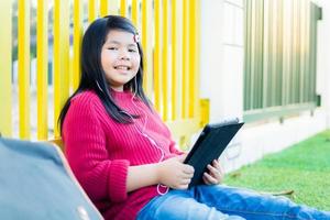 Asian girl watching a table on the school lawn photo