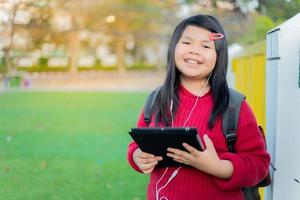 Asian girl watching a table on the school lawn photo