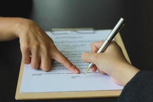 A woman signed a document to become a new employee of the office. Contract and job application concepts photo