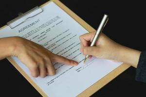 A woman signed a document to become a new employee of the office. Contract and job application concepts photo