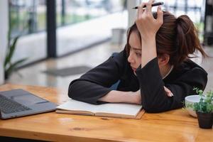 concepto de síndrome de burnout en el trabajo. mujer agotada con exceso de trabajo que trabaja en la oficina. concepto de síndrome de agotamiento.