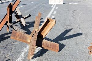 erizos soldados de metal en la calzada de una carretera de la ciudad en un día soleado. foto