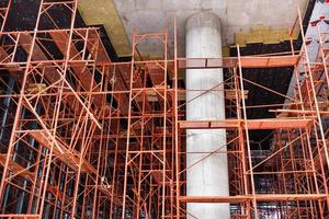 columna de hormigón entre andamios metálicos en la construcción de un nuevo edificio. foto