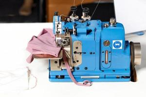 Professional blue color industrial overlock at the factory. Closeup. Copy space. photo